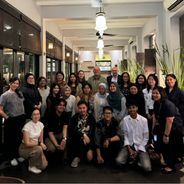 A group of UCD alumni at a global event, posing for a photo.